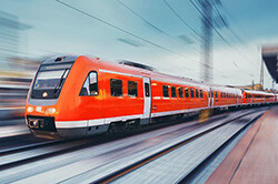Ein roter Zug fährt auf Gleisen